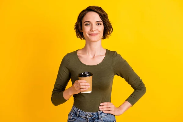 Foto de encantadora senhora segurar takeaway cappuccino copo desgaste pulôver camisa isolada sobre fundo de cor amarelo vívido — Fotografia de Stock