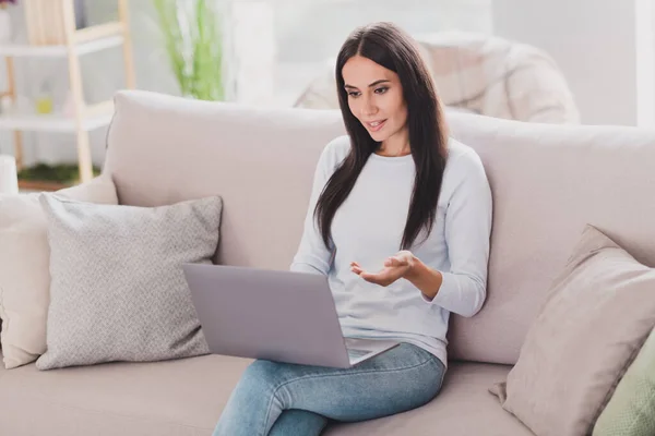 Fotografie atraktivní mladá žena mluvit video konference držení notebook na volné noze sedět gauč doma v domě — Stock fotografie