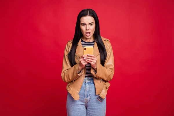 Foto de senhora negativa atraente olhando telefone boca aberta mau humor isolado no fundo de cor vermelha — Fotografia de Stock