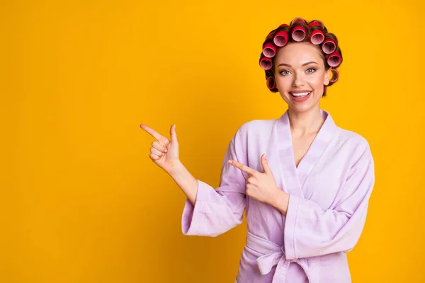 Positivo menina ponto indicador dedo copyspace spa salão de beleza anúncios promoção desgaste banho roupão isolado brilho cor fundo — Fotografia de Stock