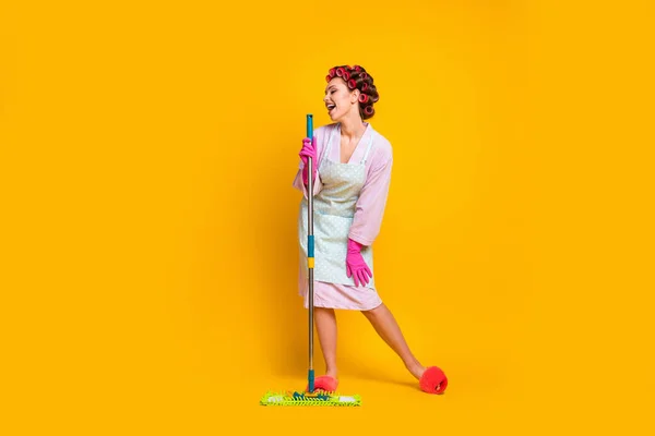 Ganzkörpergröße Ansicht der fröhlichen lustigen Mädchen singen Hit mit Wischmopp wie Mikrofon isoliert helle gelbe Farbe Hintergrund — Stockfoto