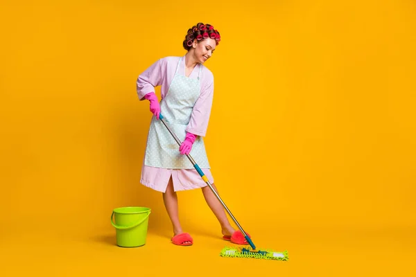 Volledige foto van positieve meisje wassen dweil vloer slijtage badjas handschoenen geïsoleerd over heldere kleur achtergrond — Stockfoto