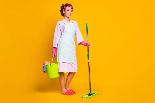 Volledige lengte foto van positieve meisje meid hold emmer dweil dragen handschoenen bad badjas geïsoleerde heldere kleur achtergrond — Stockfoto