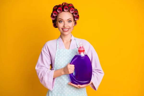 Pozitif kızın fotoğrafı. Elinde büyük bir şişe çamaşır deterjanı var. Parlak parlak arkaplandan izole edilmiş kıyafet. — Stok fotoğraf
