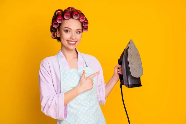 Portrait of lovely cheery maid holding in hand demonstrating new modern iron steam isolated bright orange color background — Stock Photo, Image