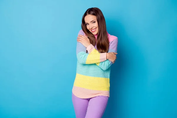 Foto de chica bonita abrazarse a sí misma disfrutar de cálido cómodo jersey usar pantalones violeta aislado fondo de color azul — Foto de Stock