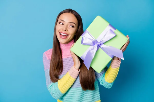 Foto de chica alegre positiva obtener caja de regalo jersey de desgaste sacudida curioso aislado sobre fondo de color azul —  Fotos de Stock