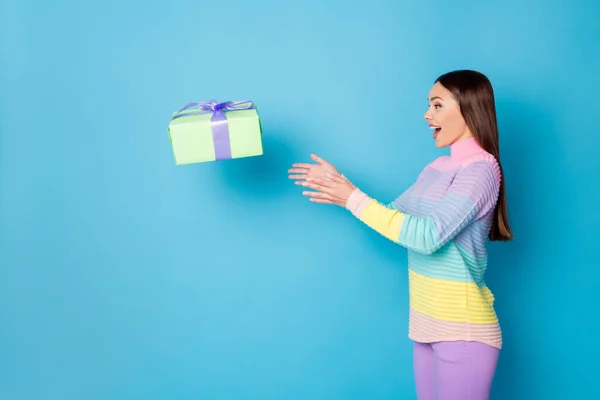 Profil sisi foto gadis heran mendapatkan hadiah kotak hadiah udara lalat menangkap mengenakan celana jumper terisolasi biru latar belakang warna — Stok Foto