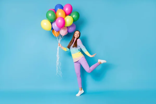 Pełna długość zdjęcie cute girl cieszyć się wiele balonów nosić gumowe izolowane na tle niebieskiego koloru — Zdjęcie stockowe