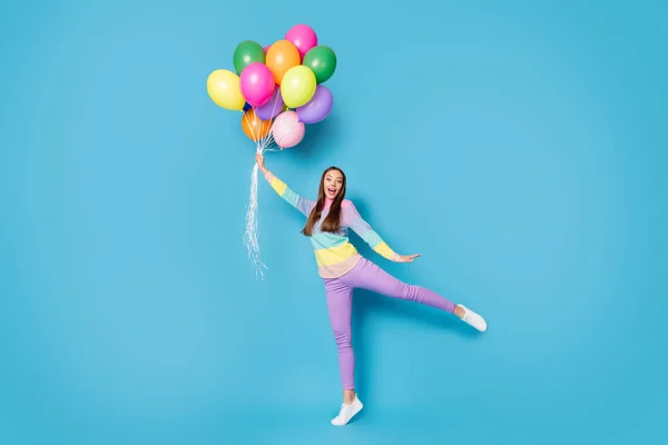 Полное фото тела изумленной девушки держать ловить воздушные шары мухи кричать носить брюки изолированы на синем фоне цвета — стоковое фото