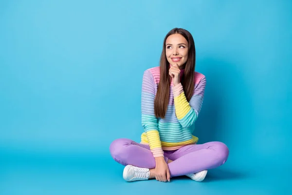 Retrato de atractiva chica alegre creativa sentada posición de loto piernas cruzadas toma de decisión aislada sobre fondo de color azul brillante —  Fotos de Stock
