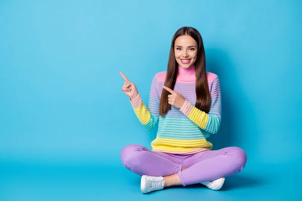 Portret van vrij vrolijk meisje zitten lotus positie gekruiste benen demonstreren kopieerruimte advertentie geïsoleerd op felblauwe kleur achtergrond — Stockfoto