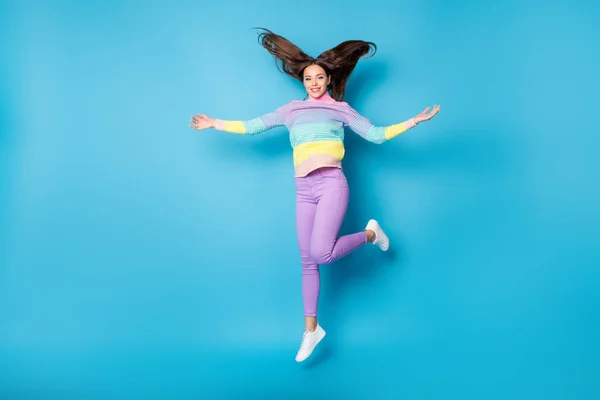 Повнометражний вигляд на тіло досить худорлява недбала фанк весела дівчина стрибає розважаючись кидаючи волосся ізольовано на яскраво-блакитному фоні — стокове фото