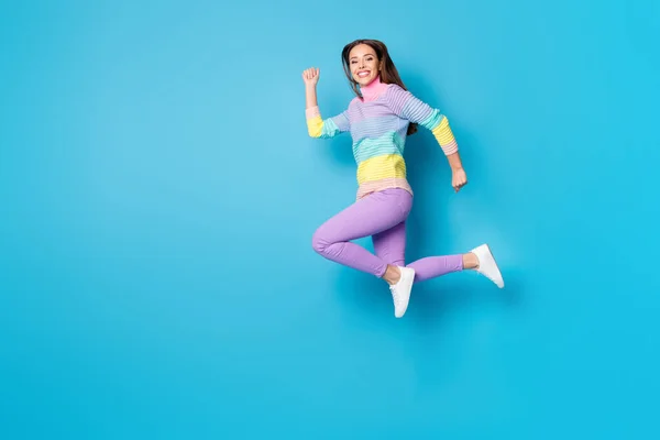 Tamanho do corpo de comprimento total vista de atraente ativa proposital alegre menina saltando correndo isolado no fundo de cor azul brilhante — Fotografia de Stock