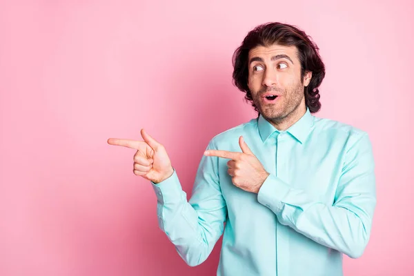 Retrato fotográfico del hombre sorprendido apuntando con dos dedos al espacio en blanco aislado sobre fondo de color rosa pastel — Foto de Stock