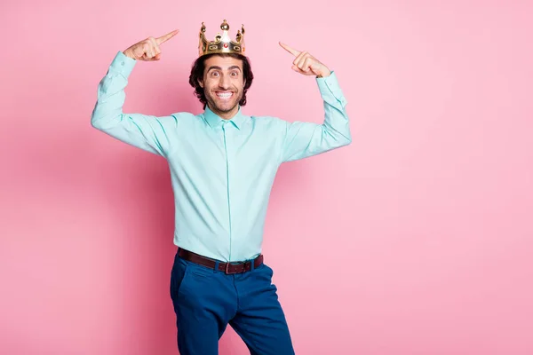 Foto retrato de tipo excitado apuntando con dos dedos a la corona en la cabeza aislado sobre fondo de color rosa pastel —  Fotos de Stock