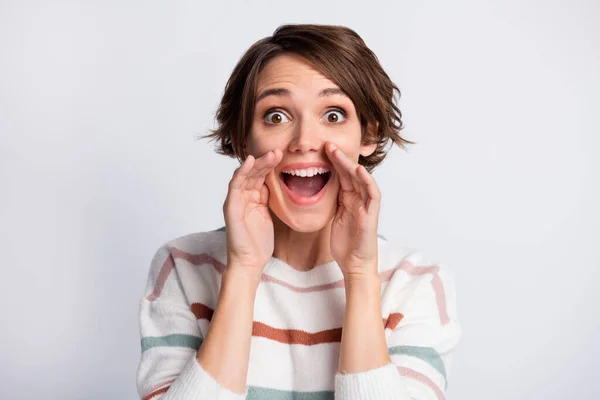 Kuva söpö viehättävä nuori nainen käyttää raidallinen villapaita kertoo uutisia aseiden suu eristetty harmaa väri tausta — kuvapankkivalokuva