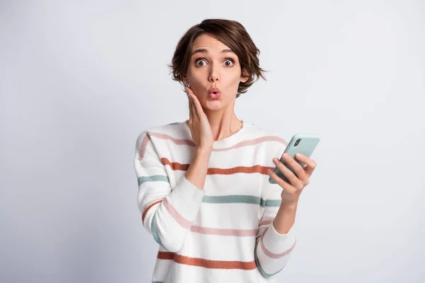 Foto van opgewonden grappige jonge dame dragen gestreepte trui met moderne gadget arm wang geïsoleerde grijze kleur achtergrond — Stockfoto