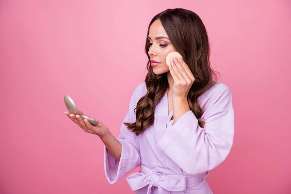 Foto de perfil de la hermosa dama larga rizado peinado celebrar bolsillo espejo preparar fecha romántica reflexión perfecta aplicar polvo pómulo desgaste albornoz aislado pastel rosa color fondo — Foto de Stock