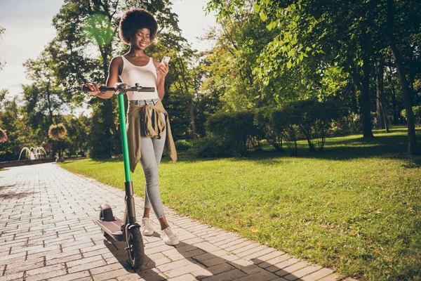 Longitud completa vista del tamaño del cuerpo de ella ella agradable atractivo delgado ajuste delgado alegre chica caminando patinete scooter disfrutando de pasar tiempo libre utilizando aplicación dispositivo 5g en aire fresco al aire libre —  Fotos de Stock