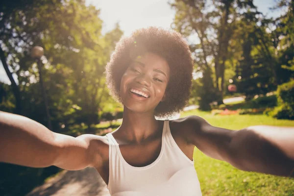 Foto portret van glimmende lachende vrouw schieten selfie in zonneschijn in park — Stockfoto