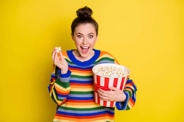 Foto von jungen Mädchen Filmkomödie essen Popcorn tragen gestreiften Pullover isoliert über gelben Farbhintergrund — Stockfoto