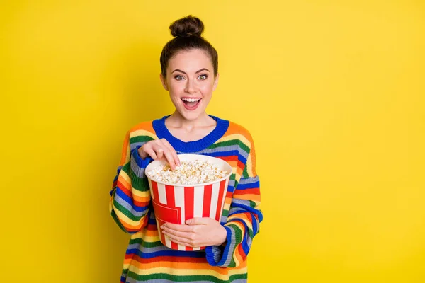 Foto von jungen attraktiven Frau glücklich lächeln halten Popcorn-Box essen Film sehen isoliert über gelben Farbhintergrund — Stockfoto