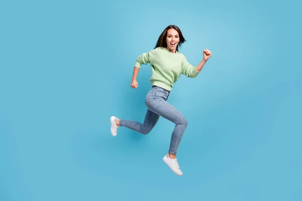 Teljes hossz testméret oldalsó profil fotó nevető fiatal lány gyorsan fut fel ugrás magas mosolygós boldogan elszigetelt élénk kék háttér — Stock Fotó