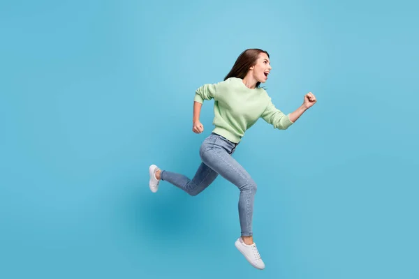 Teljes hossz testméret oldalsó profil fénykép vidám női diák fut gyorsan ugrás magas nevetve elszigetelt élénk kék háttér — Stock Fotó