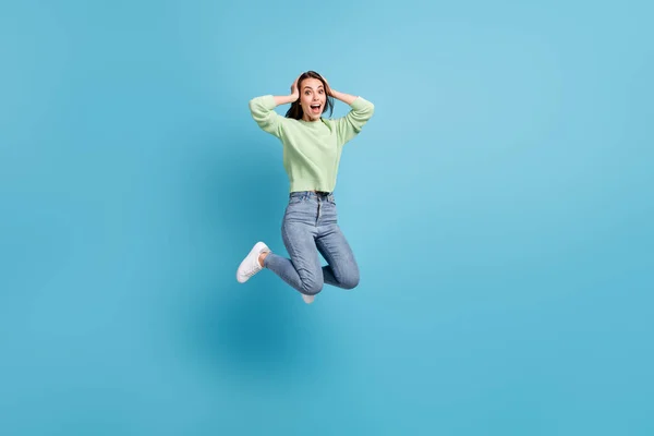 Lunghezza completa dimensioni del corpo foto di impressionato stupito scioccato studentessa saltando in alto tenendo le mani sulla testa isolato su sfondo di colore blu vivido — Foto Stock