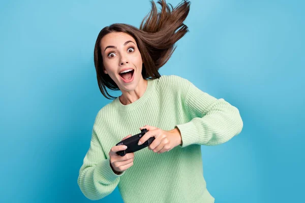 Retrato fotográfico de una chica bastante divertida jugando a videojuegos manteniendo la consola gritando en voz alta aislada sobre un vibrante fondo de color azul —  Fotos de Stock