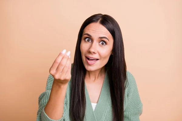 Portret van optimistisch meisje vragen geld dragen groene trui geïsoleerd op perzik kleur achtergrond — Stockfoto