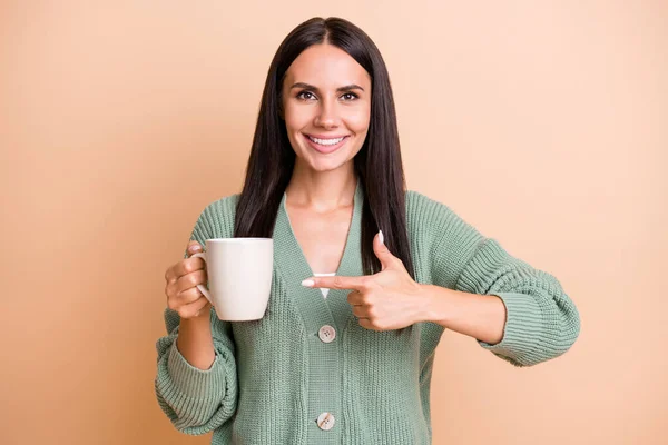 Potret gadis optimis titik cangkir memakai sweter hijau terisolasi pada warna latar belakang persik — Stok Foto