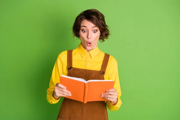 Foto von aufgeregten jungen Dame aussehen Lehrbuch lesen offenen Mund tragen gelbes Hemd insgesamt isoliert grüne Farbe Hintergrund — Stockfoto