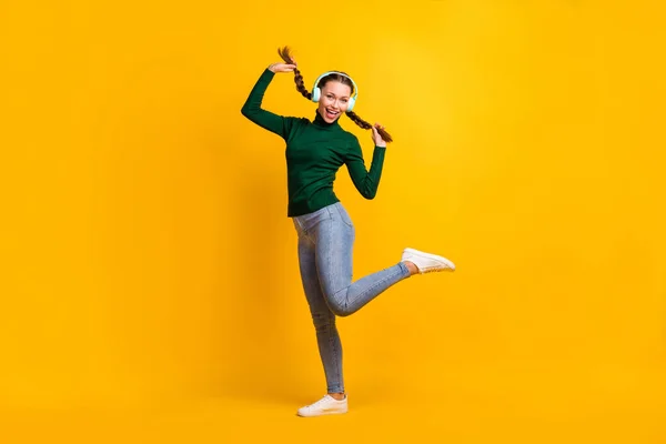 Longitud completa tamaño del cuerpo foto estudiante disfrutando de la música con auriculares sonriendo aislado en el fondo de color amarillo vibrante — Foto de Stock