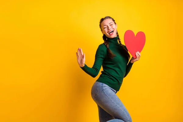 Photo portrait dreamy dancing girl with red heart postcard laughing isolated bright yellow color background with copyspace — Stock Photo, Image