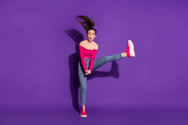 Повнометражний вигляд на тіло привабливої гнучкої веселої дівчини, що стрибає з веселощами на губах, ізольовані яскраво-фіолетовий кольоровий фон — стокове фото