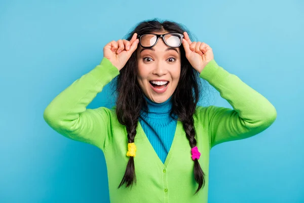 Fotografie šťastný pěkný ohromen mladá žena držet prsty brýle překvapená reakce izolované na lesk modré barvy pozadí — Stock fotografie