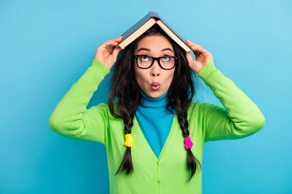 Foto van nieuwsgierige funky schok jonge vrouw houden boek boven hoofd lezen slijtage bril geïsoleerd op blauwe kleur achtergrond — Stockfoto