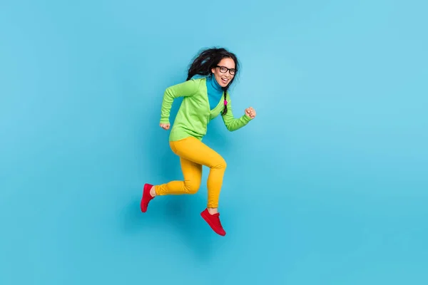 Foto lateral de perfil de longitud completa de la mujer joven de moda funky correr saltar hasta copyspace aire aislado en el fondo de color azul brillante —  Fotos de Stock