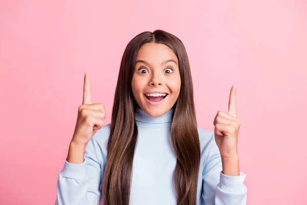 Ritratto della bambina impressionato bocca aperta dito diretto fino usura dolcevita blu isolato su sfondo di colore rosa — Foto Stock