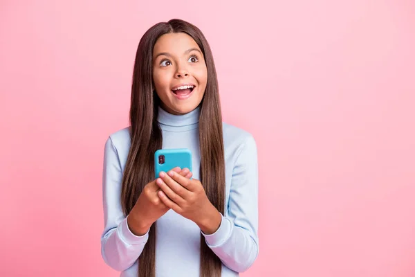 Retrato de menina criativa muito alegre espantado usando gadget criando ideia espaço de cópia isolado sobre cor pastel rosa fundo — Fotografia de Stock