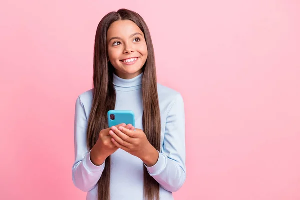Retrato de linda menina alegre usando gadget pensamento comentário cópia espaço isolado sobre cor pastel rosa fundo — Fotografia de Stock