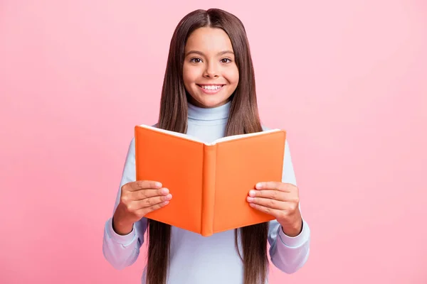 Retrato de contenido encantador alegre cerebrito chica de cabello castaño leyendo libro académico aislado sobre fondo de color pastel rosa —  Fotos de Stock
