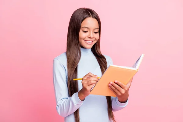 Retrato de chica morena alegre enfocada encantadora escribiendo notas en diario libro de ejercicios aislado sobre fondo de color pastel rosa — Foto de Stock