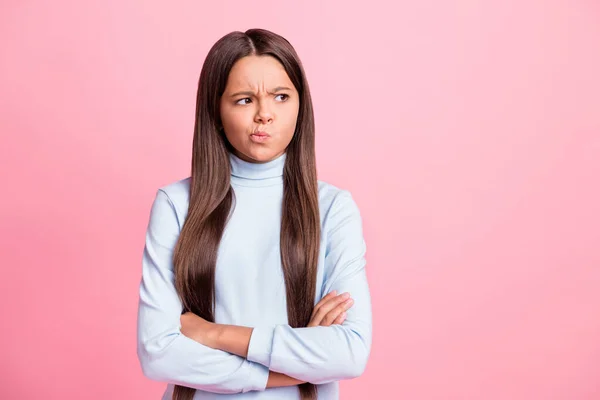 Retrato de menina de cabelos castanhos muito insatisfeito dobrou os braços olhando para o lado sorrindo isolado sobre fundo cor pastel rosa — Fotografia de Stock