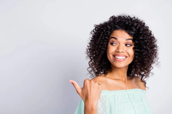 Foto retrato de menina olhando para trás polegar apontando para o espaço em branco isolado no fundo de cor branca — Fotografia de Stock