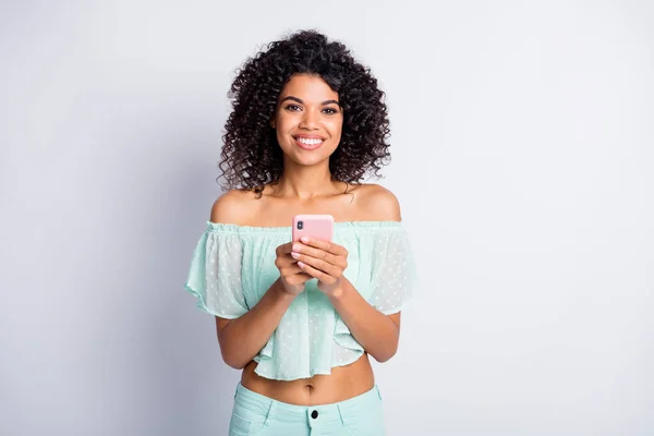 Foto portret van een gelukkige vrouw met telefoon in twee handen geïsoleerd op wit gekleurde achtergrond — Stockfoto