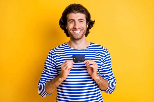 Foto de cara positivo Oriente Médio segurar cartão de crédito desgaste azul branco colete náutico isolado no brilho cor amarela fundo — Fotografia de Stock