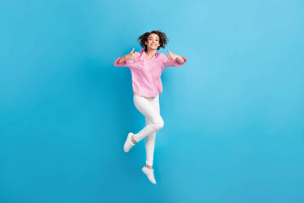 Foto de corpo inteiro de salto menina positiva mostrar polegar para cima sinal desgaste rosa roupas formais gumshoes isolado no fundo de cor azul — Fotografia de Stock
